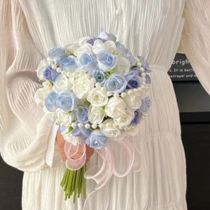 Dusty blue artificial bridesmaid bouquet with a pearl-wrapped handle, held in one hand
