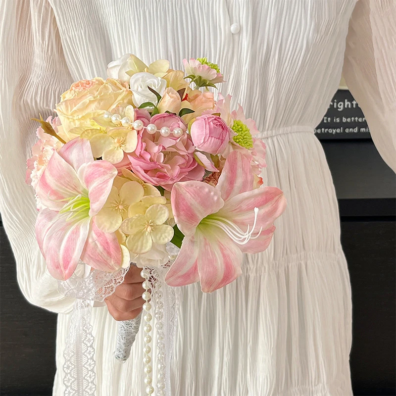 Peach artificial bridesmaid bouquet with a pearl-wrapped handle, held in one hand