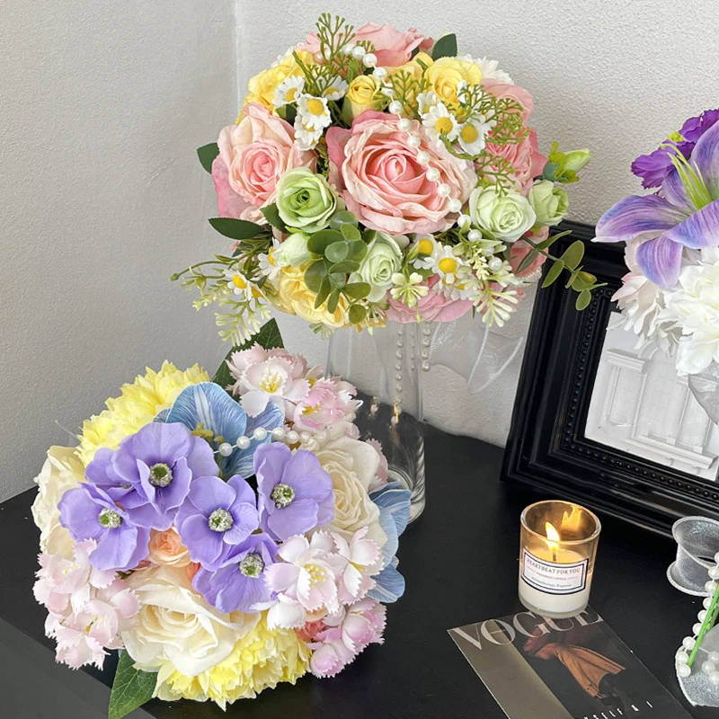 Artificial bridesmaid bouquet with a pearl-wrapped handle, styled on a table top