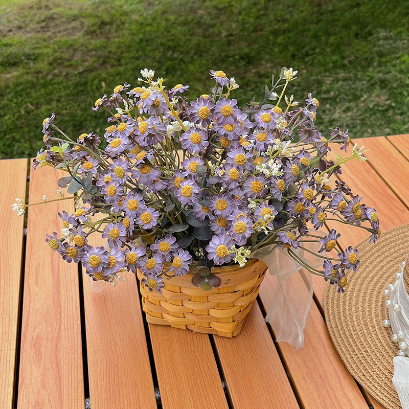 Lilac daisy artificial daisy plant in a basket massed into a dense dome, styled on a table top