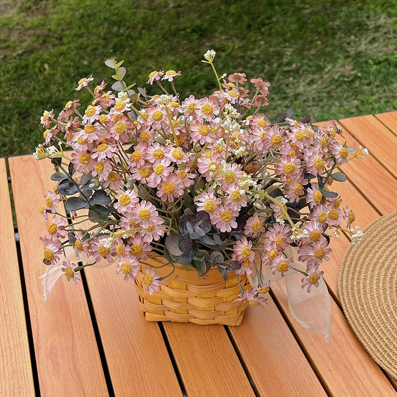 Pink daisy artificial daisy plant in a basket massed into a dense dome, styled on a table top