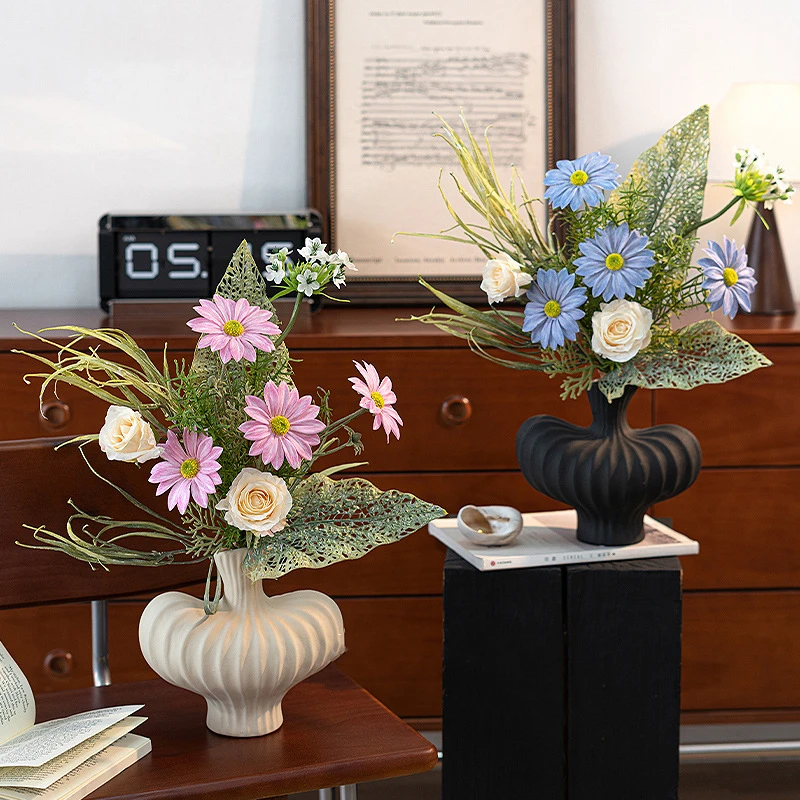 Artificial daisy and skeleton leaf posy with lace-veined skeleton leaves, arranged in a vase