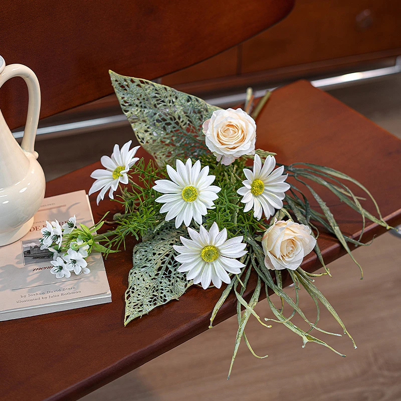 Artificial daisy and skeleton leaf posy with lace-veined skeleton leaves, styled on a table top