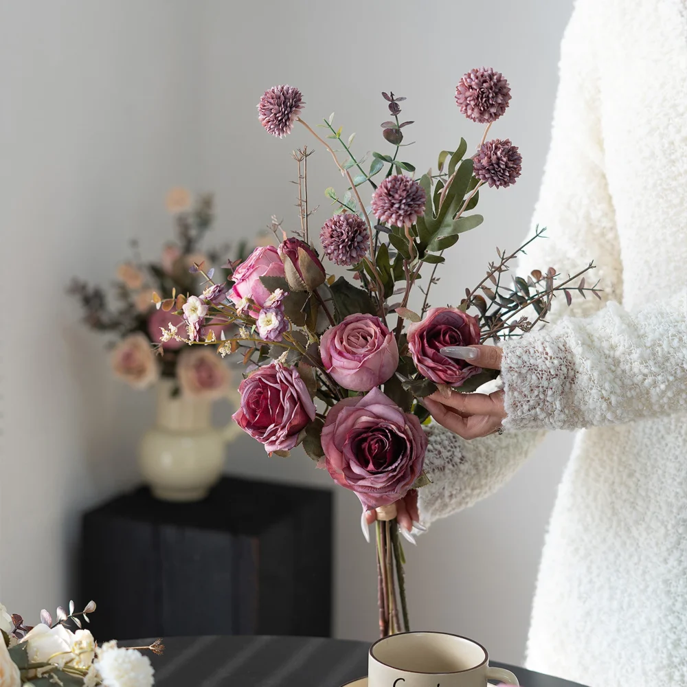 Artificial rose and eucalyptus bouquet built on a frame of eucalyptus stems, arranged in a vase