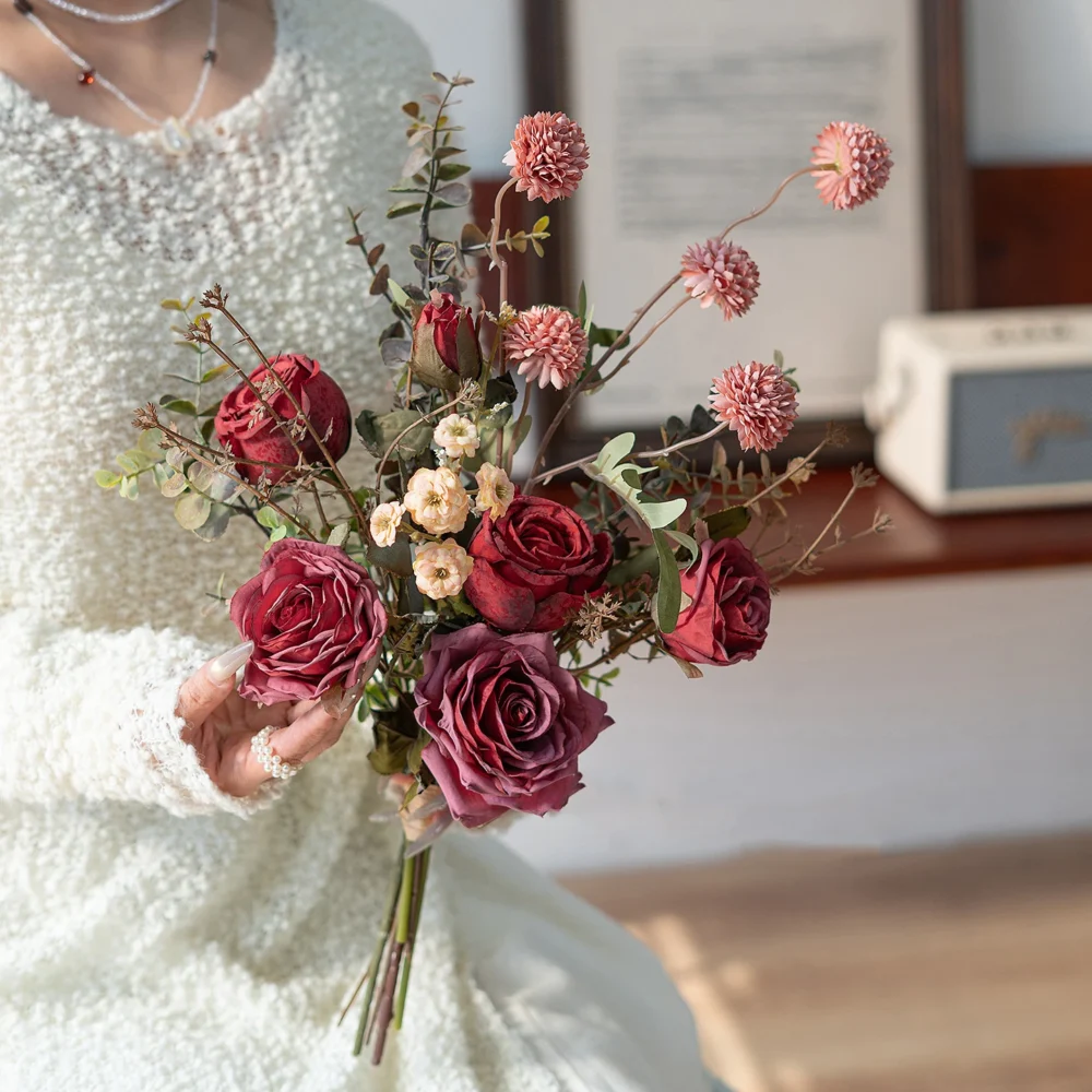 Artificial rose and eucalyptus bouquet built on a frame of eucalyptus stems, styled in a room setting