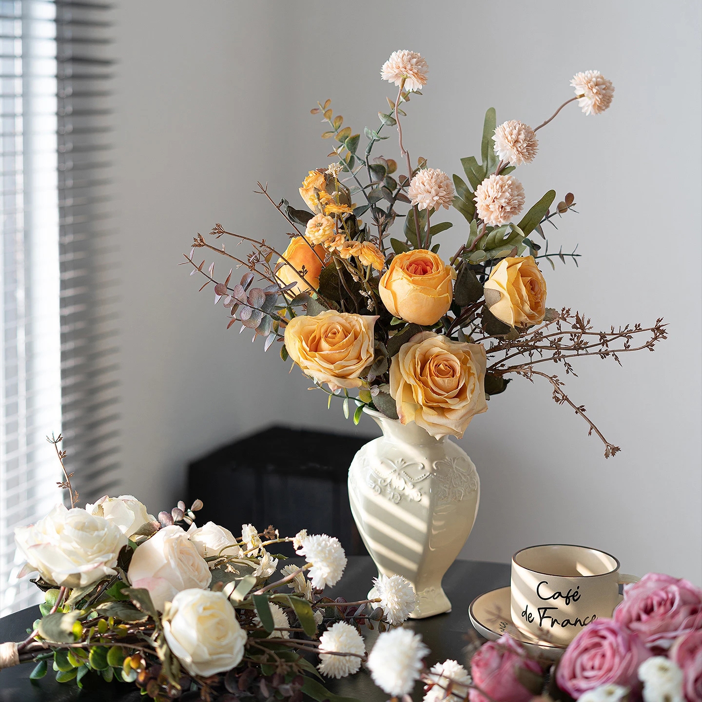 Artificial rose and eucalyptus bouquet built on a frame of eucalyptus stems, styled on a table top