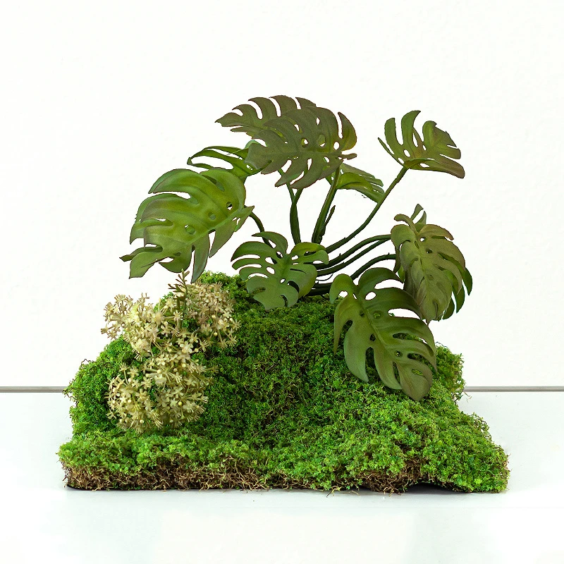 Monstera artificial fern arrangement rooted into a raised moss mound