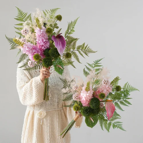 Artificial fern and flower bouquet built round a fan of fern fronds, styled in a room setting