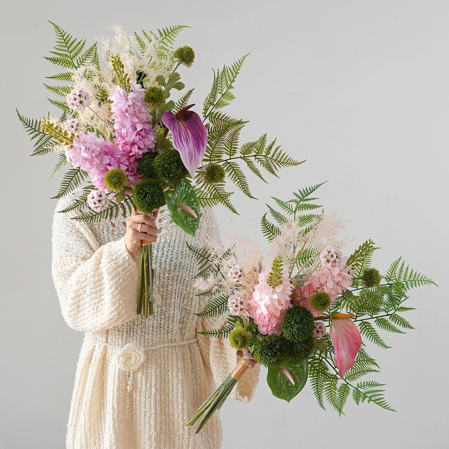 Artificial fern and flower bouquet built round a fan of fern fronds, styled in a room setting
