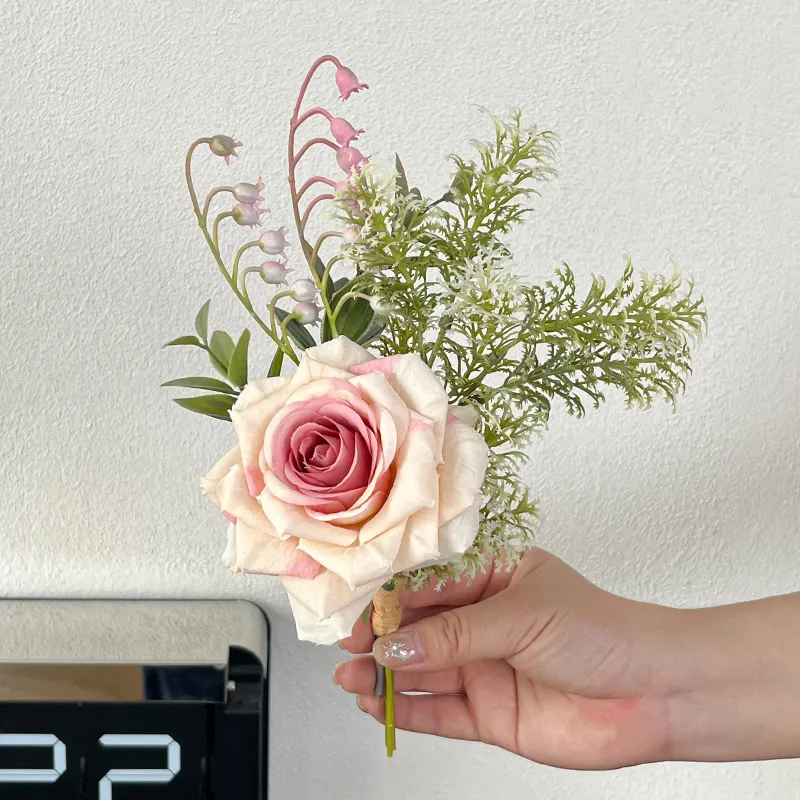 Pink fern artificial flower posy of hand-tied silk blooms and foliage, held in one hand