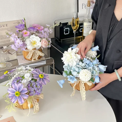 Artificial flower arrangement in a pot with a lace tie shown close up