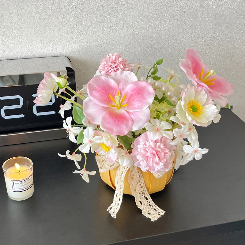 Pink hibiscus artificial flower arrangement in a pot with a lace tie, styled on a table top