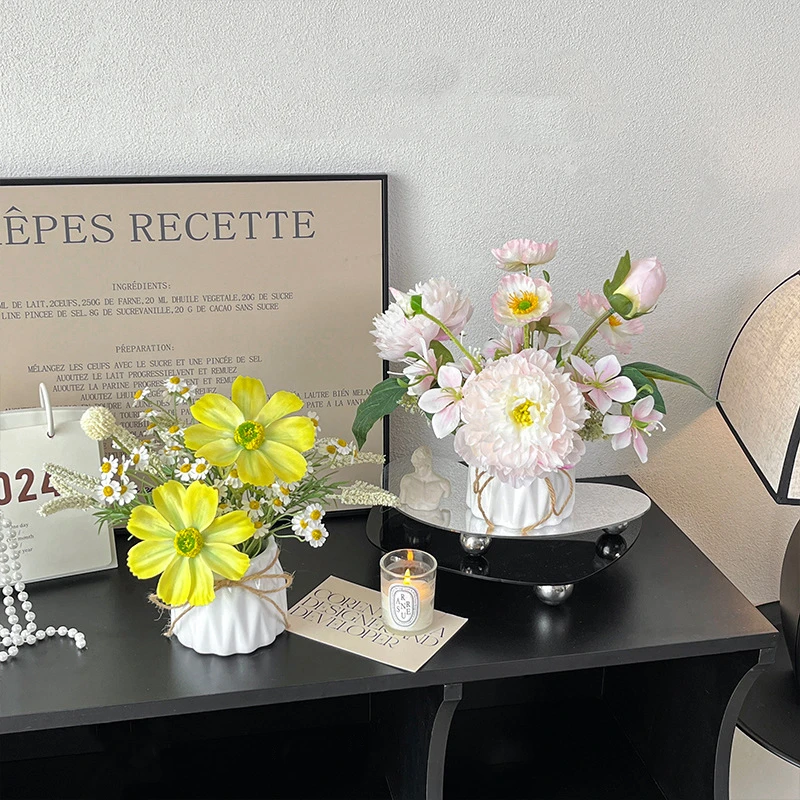 Artificial flower arrangement in a vase in a fluted white ceramic pot, styled in a room setting