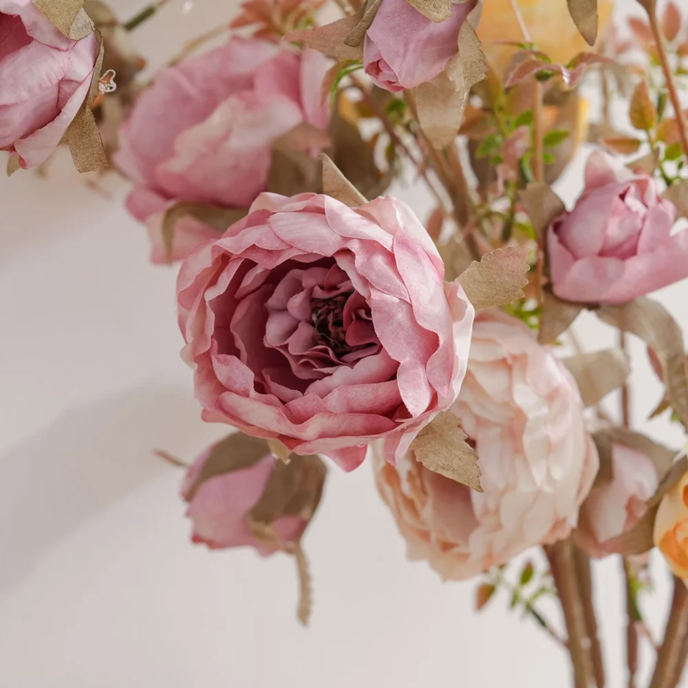 Pink artificial garden rose spray stem with open blooms and tight buds shown close up