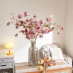 Artificial garden rose spray stem with open blooms and tight buds, styled in a room setting