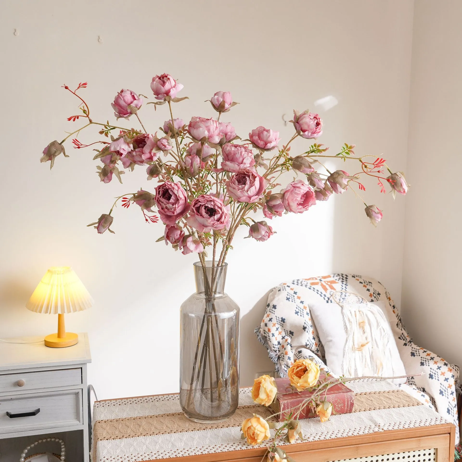 Artificial garden rose spray stem with open blooms and tight buds, styled in a room setting