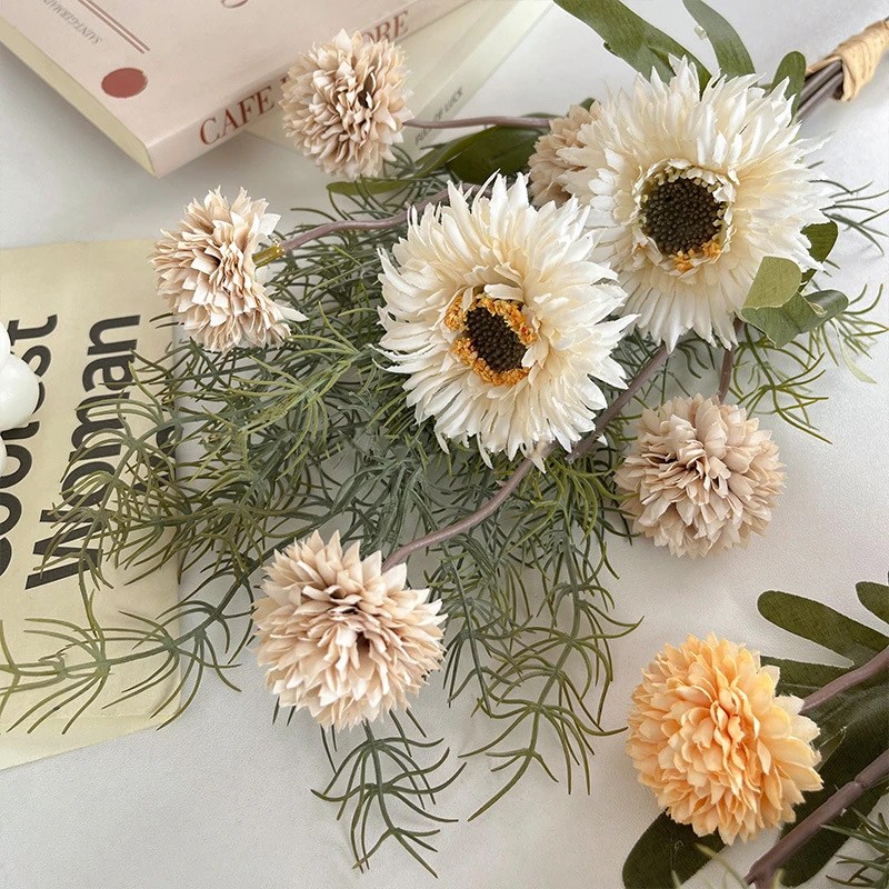Artificial gerbera and pompom bunch in muted cream and caramel, styled on a table top