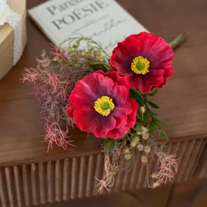 Artificial poppies and snake plant leaves styled in a warm room setting