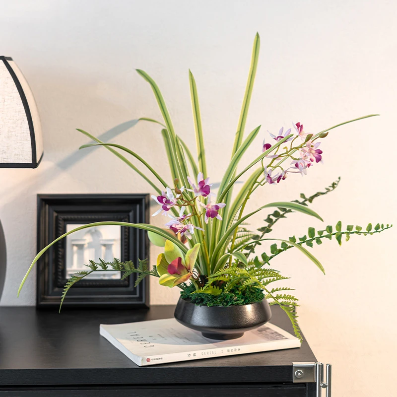 Pink orchid artificial ikebana arrangement in a low black bowl, styled in a room setting