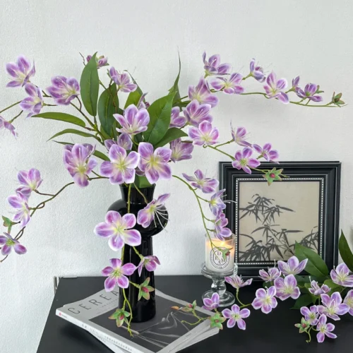 Long stem artificial flower spray with small five-petal blooms on a fine branching stem, arranged in a vase
