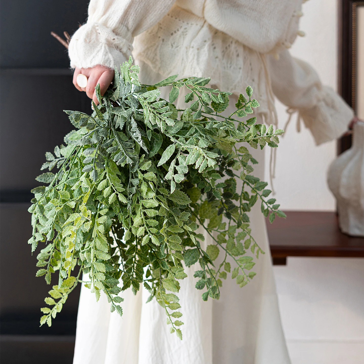 Dusty green artificial maidenhair fern stem on fine black wire stems, styled in a room setting