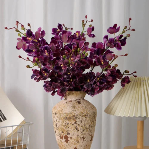 Plum artificial Vanda orchid stem with real touch petals and buds, styled in a room setting