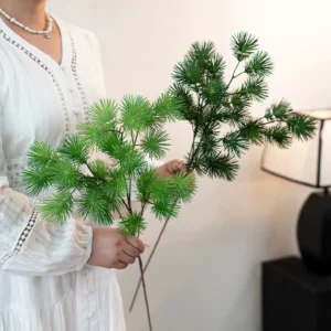 Artificial pine branch with soft needled side shoots on a brown stem shown close up