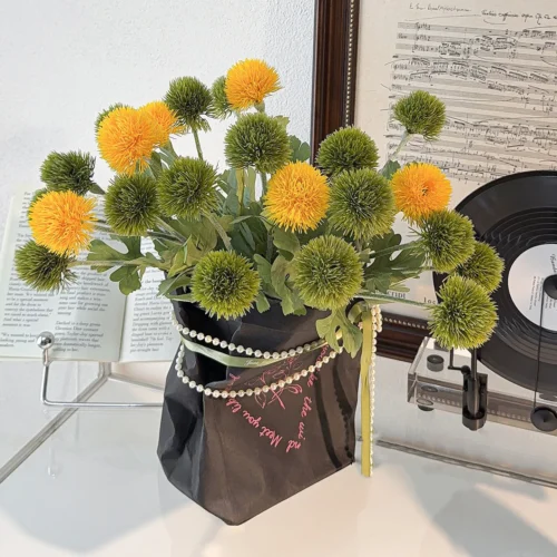 Artificial pompom chrysanthemum stem with a dense spiky head, styled in a room setting