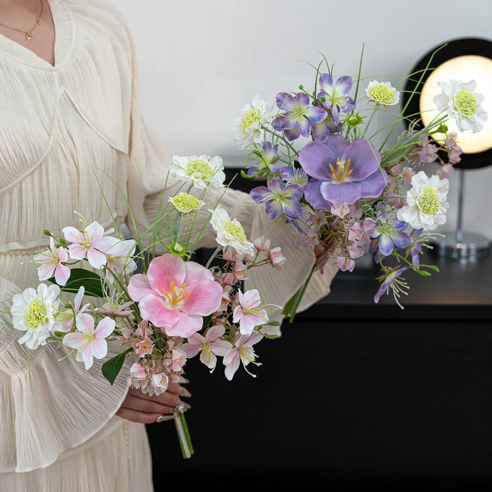 Pink and blue artificial spring bouquet in blue and white of blue poppies, white blossom and fine grasses, styled in a room setting