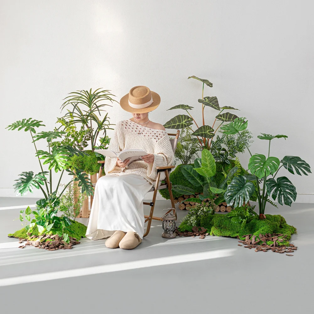 Artificial tropical plant display on a wide moss floor, styled in a room setting