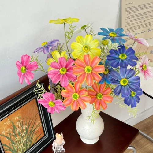 Big artificial cosmos stem with oversized open flower heads, arranged in a vase