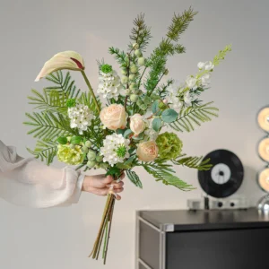 Cream and green botanical artificial flower bouquet of orchids, calla lilies, caladium leaves and ferns, held in one hand