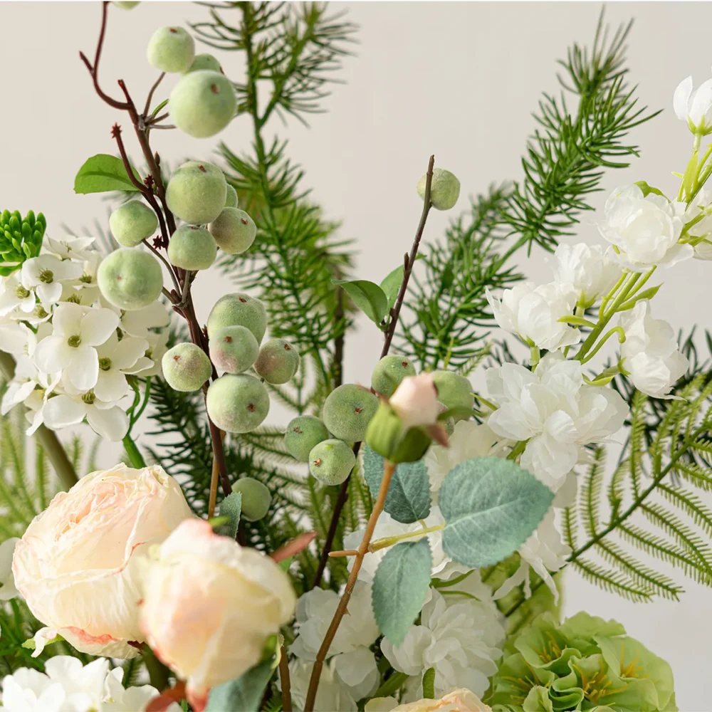 Green berry botanical artificial flower bouquet of orchids, calla lilies, caladium leaves and ferns shown close up