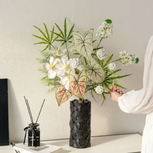 Botanical artificial flower bouquet of orchids, calla lilies, caladium leaves and ferns, styled in a room setting
