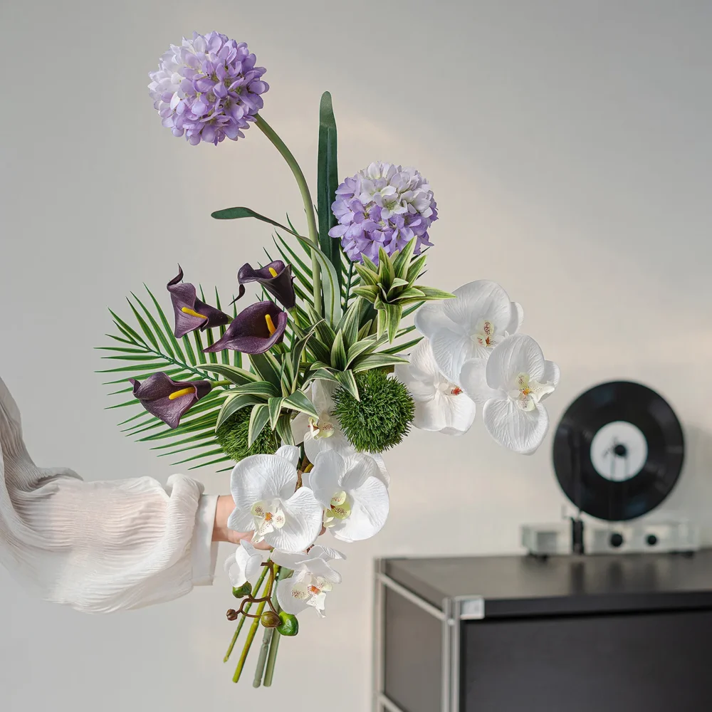 White orchid botanical artificial flower bouquet of orchids, calla lilies, caladium leaves and ferns, held in one hand