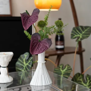 Artificial bud vase arrangement of two anthurium and one spiked green stem, arranged in a vase