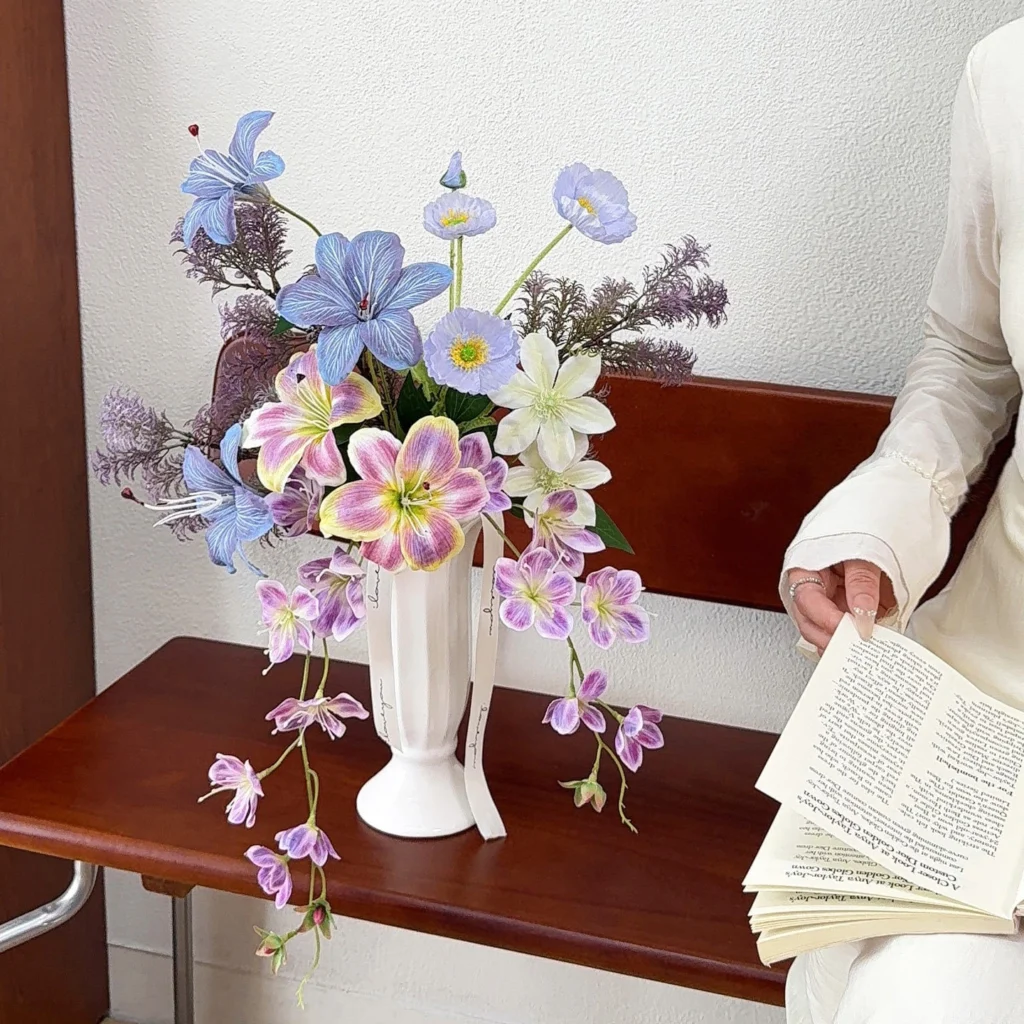 Artificial cascading wedding bouquet with a long trailing tail and ribbon, styled in a room setting