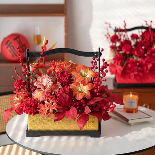 On a glass table with a candle artificial Chinese New Year arrangement in a black wooden carry frame, styled in a room setting