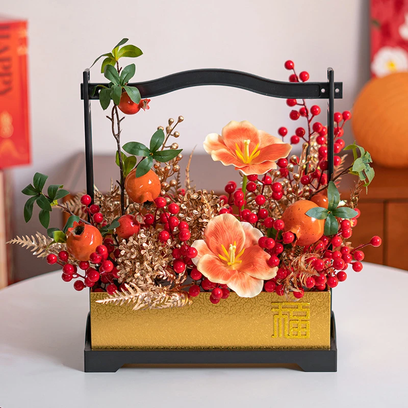 Tangerine artificial Chinese New Year arrangement in a black wooden carry frame, styled on a table top