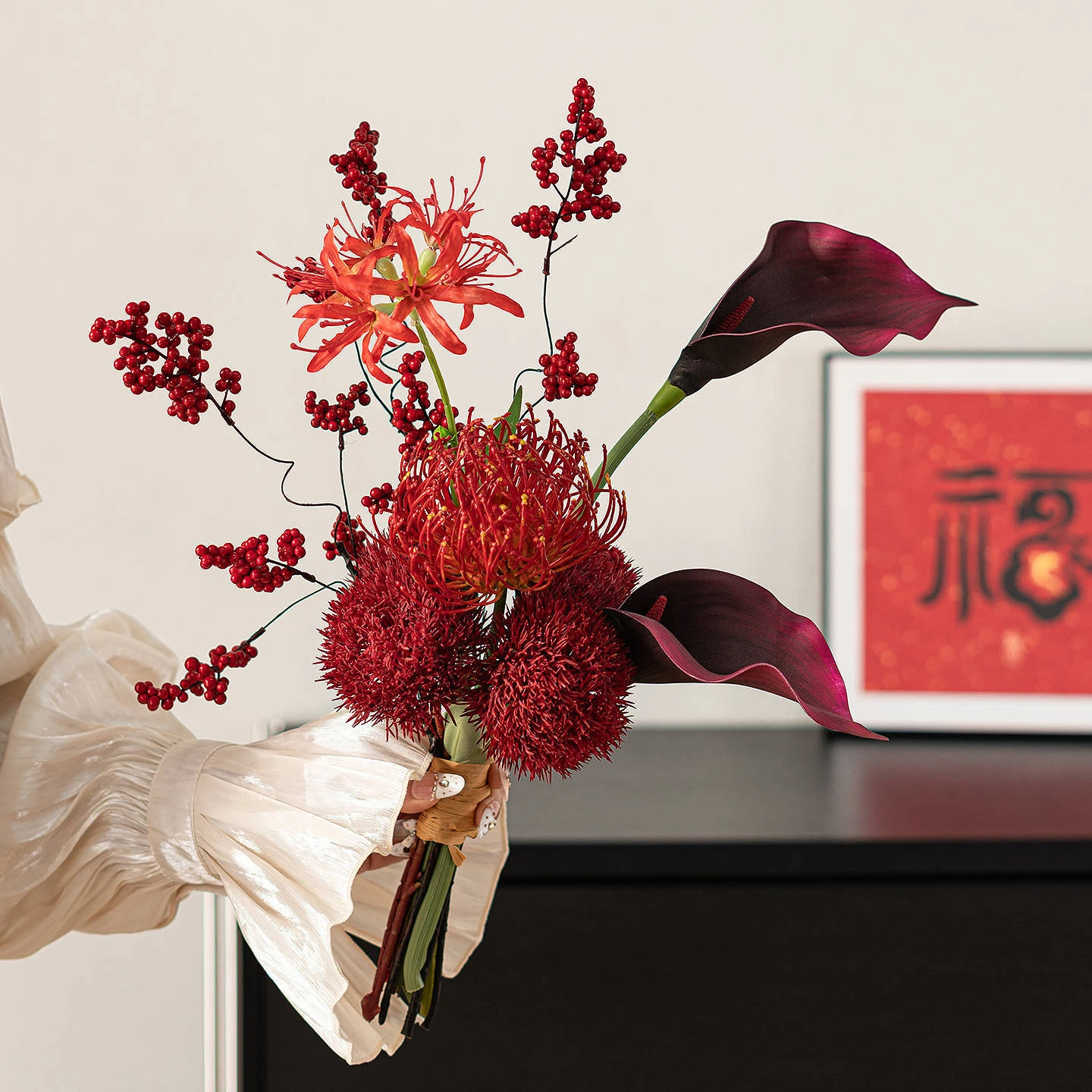 Calla and protea artificial Chinese New Year bouquet wrapped in cream paper, styled on a table top