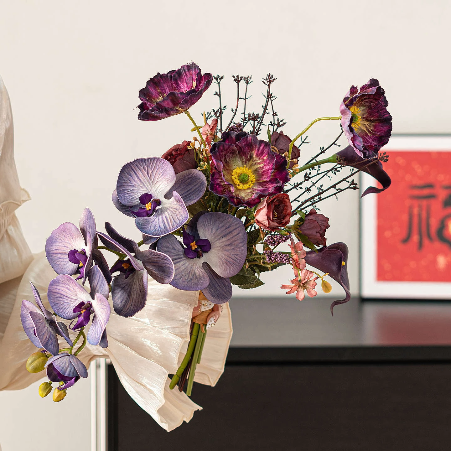 Purple orchid artificial Chinese New Year bouquet wrapped in cream paper, styled on a table top