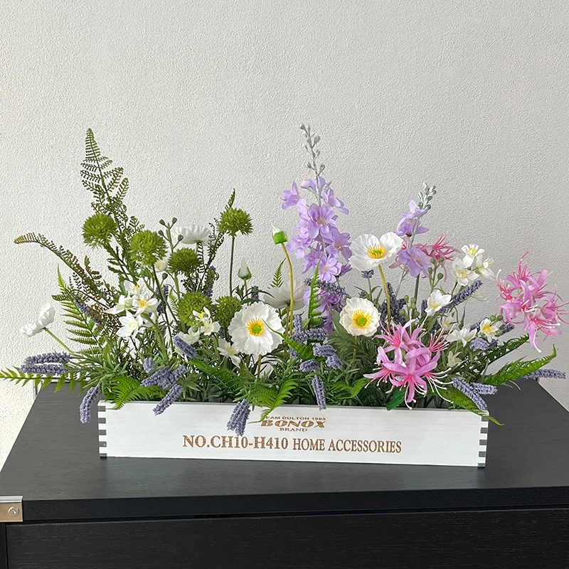 Lilac and pink artificial dining table centrepiece in a long white wooden trough, styled on a table top