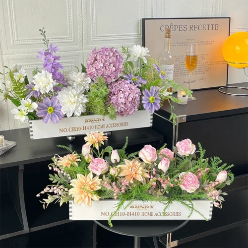 Artificial dining table centrepiece in a long white wooden trough, styled in a room setting