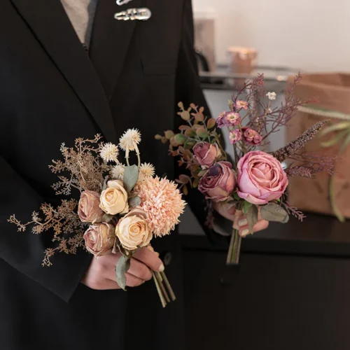 Dusty pink dried look artificial wedding bouquet of muted roses, seed heads and bare twigs with the full colour range