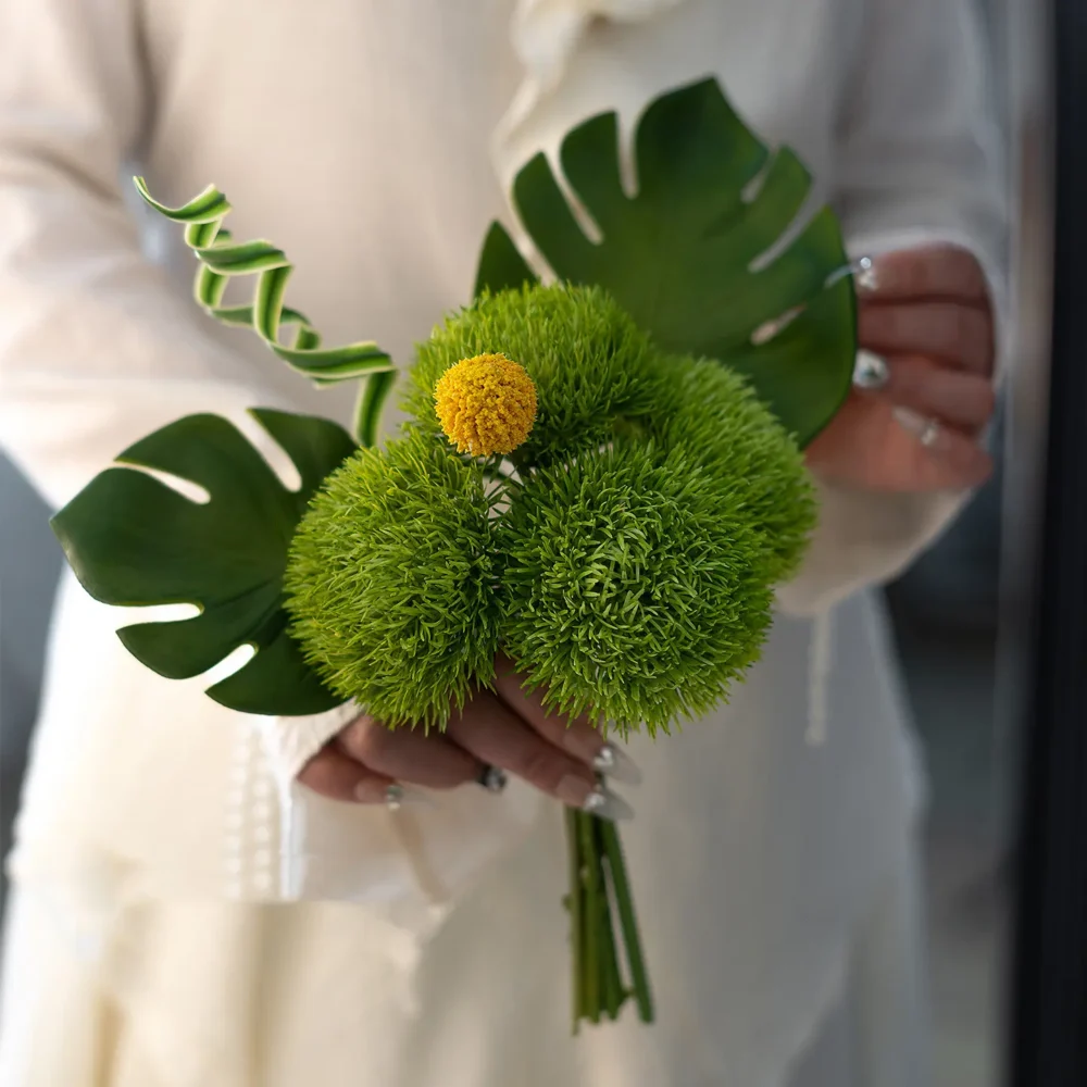 Monstera green artificial wedding bouquet of green dianthus balls and yellow billy buttons, held in one hand