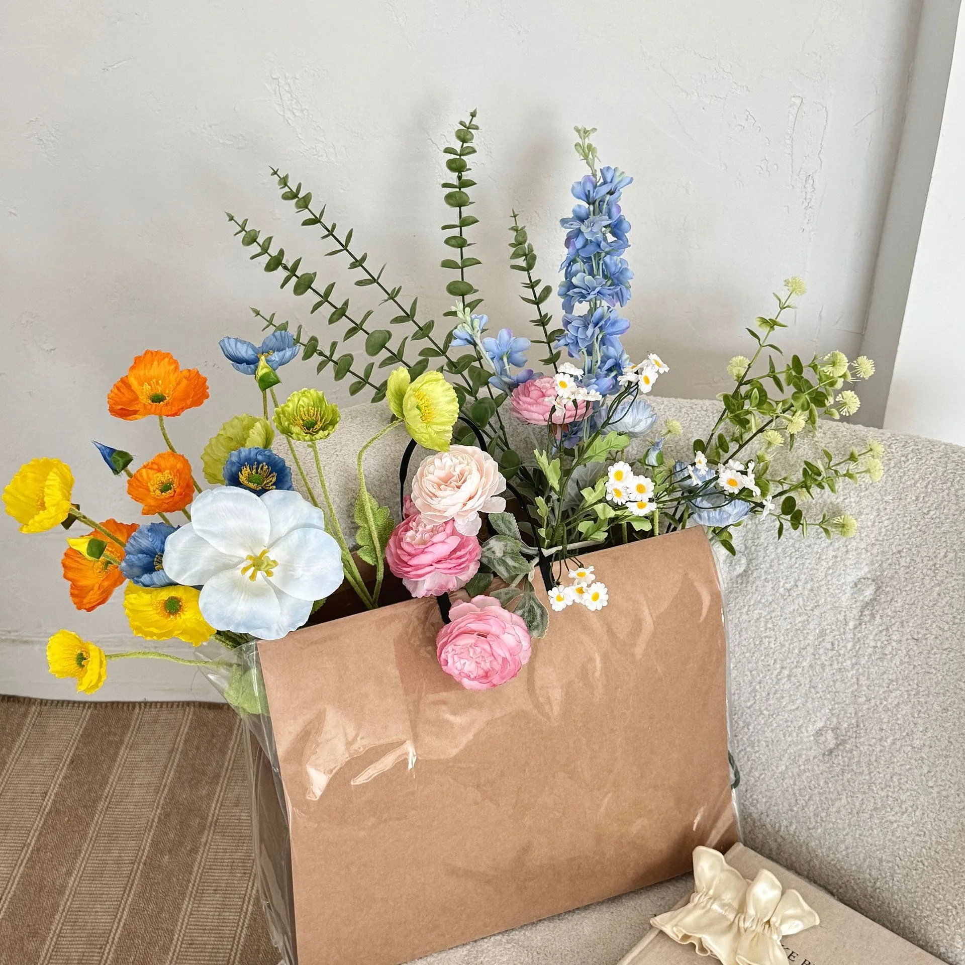 Large artificial flower bouquet of mixed silk spring blooms, styled in a room setting
