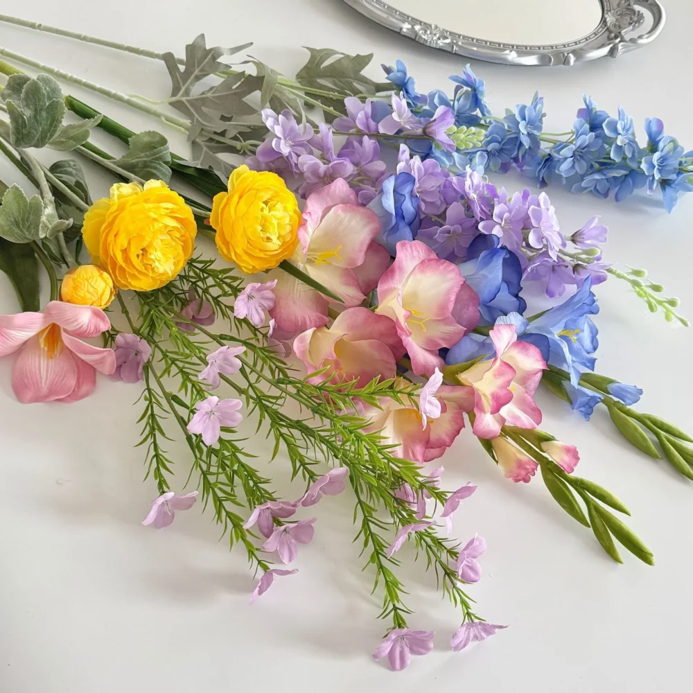 Yellow and lilac large artificial flower bouquet of mixed silk spring blooms, styled on a table top