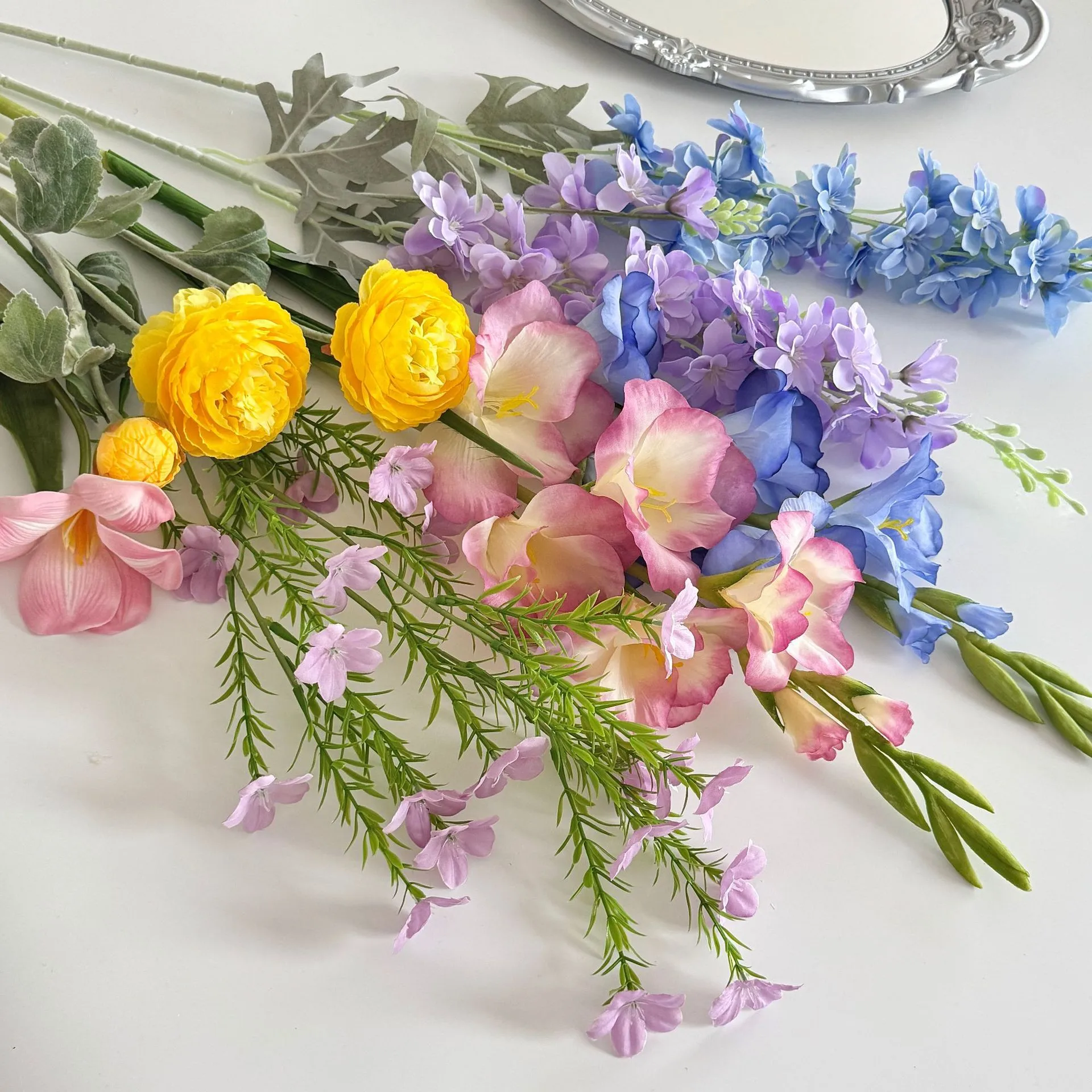 Yellow and lilac large artificial flower bouquet of mixed silk spring blooms, styled on a table top