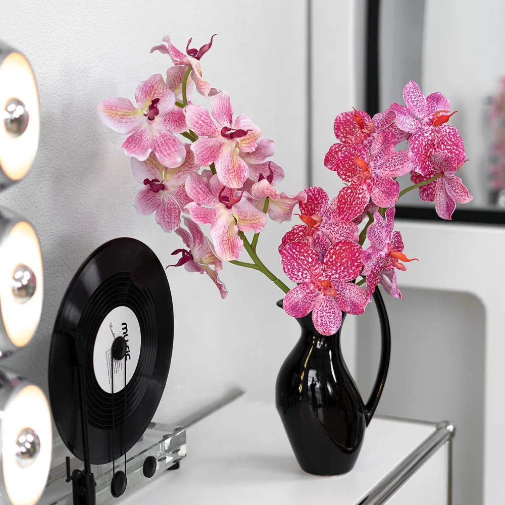 Large artificial orchid spray with a dense head of speckled vanda blooms, styled in a room setting