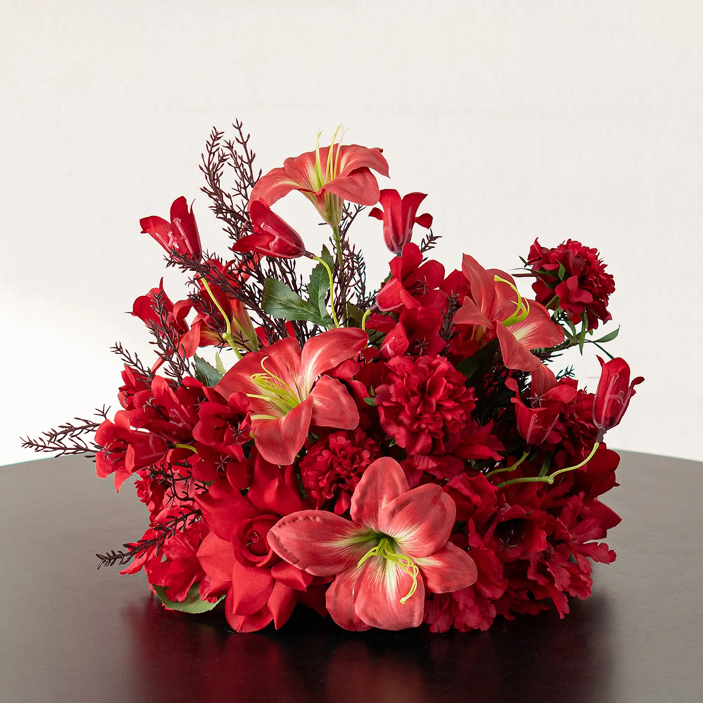 Red amaryllis red artificial flower table arrangement in a low black base